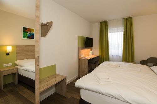 a hotel room with a bed and a desk at Roca Restaurant und Hotel in Bommersheim