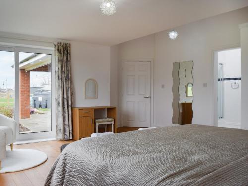a bedroom with a bed and a desk and a window at The Crofts in Winsford