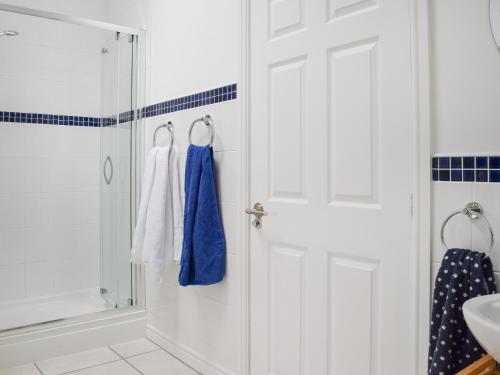 a bathroom with a shower and a white door at The Crofts in Winsford