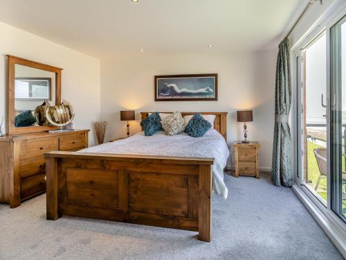 a bedroom with a bed and a large window at Beachview in Llanelli