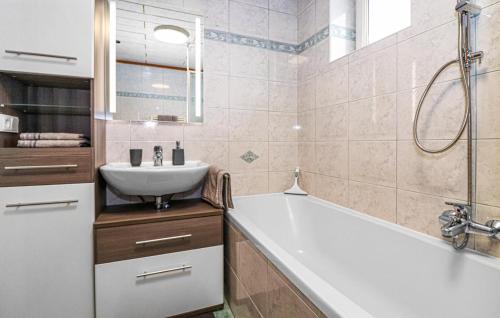 a bathroom with a tub and a sink and a bath tubermottermott at Cozy Apartment In Puch Bei Hallein With Kitchen in Puch bei Hallein