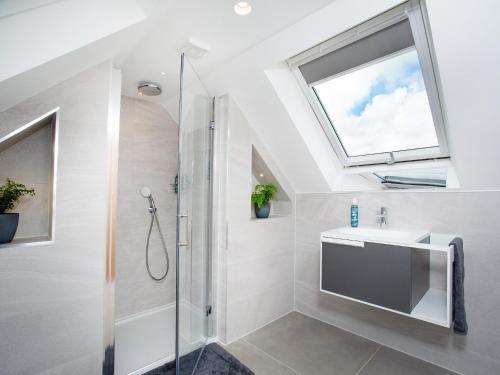 a bathroom with a shower and a sink and a window at Deer View in Ottery Saint Mary