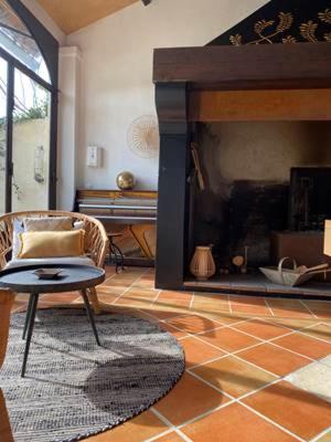 a living room with a chair and a fireplace at Le Mas des Perrines Maison d’Hôtes in Pernes-les-Fontaines