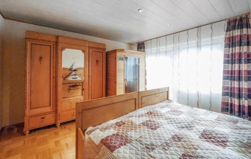 HinterweidenthalにあるBeautiful Apartment In Hinterweidenthal With 2 Bedrooms And Wifiのベッドルーム1室(ベッド1台付)、木製キャビネットが備わります。