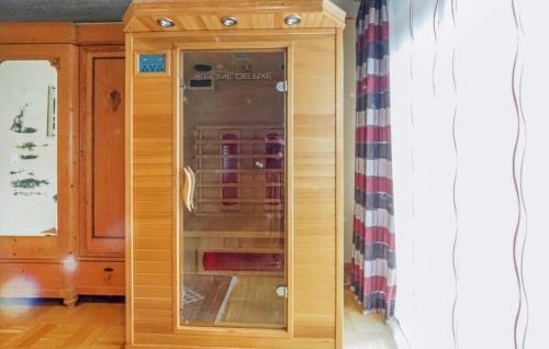 um armário de madeira com uma porta de vidro num quarto em Stunning Apartment In Hinterweidenthal With House A Mountain View em Hinterweidenthal
