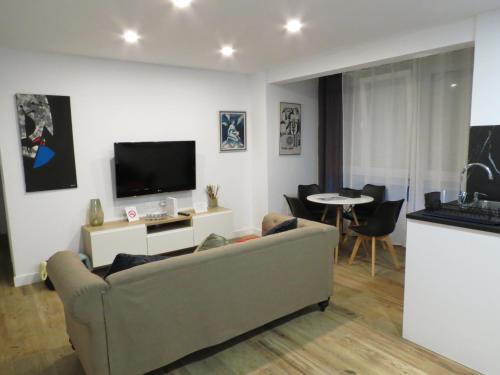 a living room with a couch and a tv at Apartamento AIRES DEL NORTE, con WiFi gratis in Santander