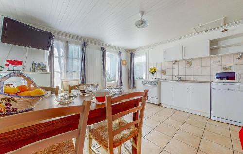 une cuisine avec une table avec un bol de fruits dessus dans l'établissement Cozy Home In Montmorillon With Wi-Fi, à Montmorillon