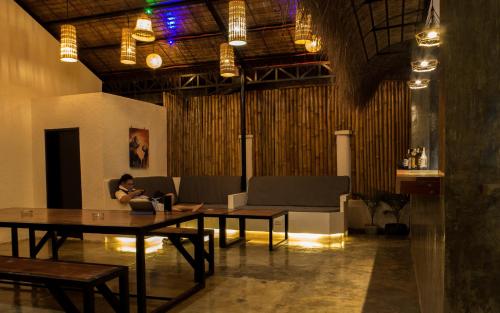 a woman sitting on a couch in a room with a table at Wild Monkeys Hostel in Moalboal