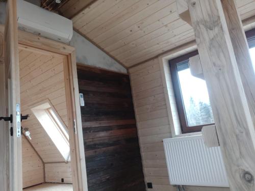 an attic room with a door and a window at Trzy Kopce 