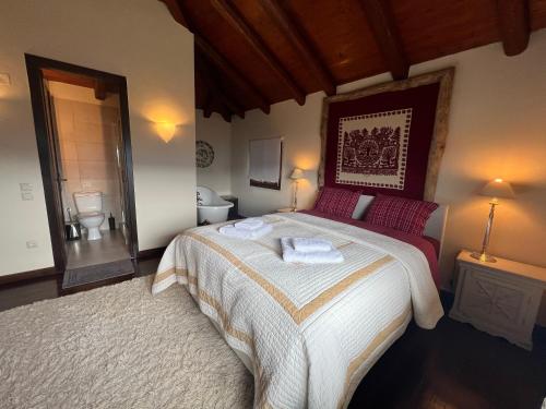 a bedroom with a large bed with two towels on it at Araxova villa ELGREKO in Arachova