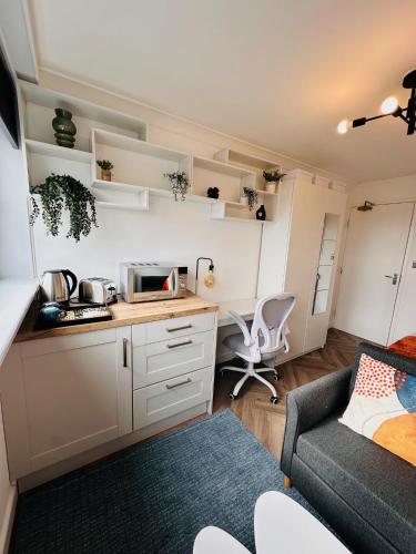 a small kitchen with a couch and a microwave at Private Room in Modern Shared Apartment, Each with Kitchenette, Central Birmingham R2 in Birmingham