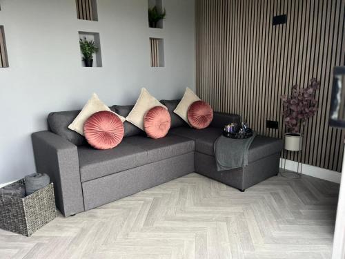 a living room with a couch with pillows on it at North Wales Eco Lodges in Ruthin