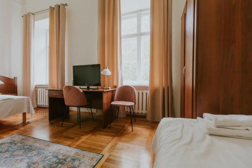 a bedroom with a desk with a computer and two chairs at Dwór Zbożenna in Przysucha