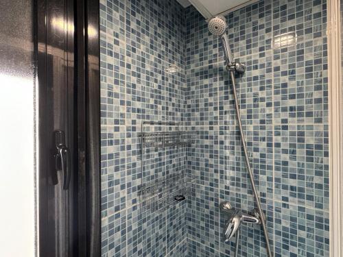 a blue tiled bathroom with a shower with at Apartamento céntrico con terraza in Córdoba