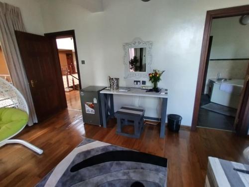 een woonkamer met een tafel en een spiegel bij Florances Rest House in Nairobi