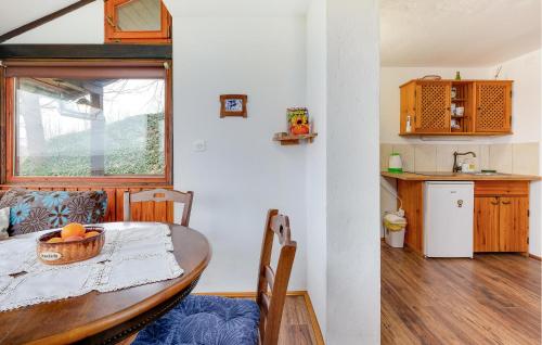 une salle à manger avec une table et une cuisine dans l'établissement Nice Home In Veliki Grdevac With Kitchen, 