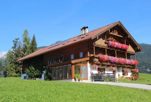 a building with flowers on the side of it at Bauernhaus Durrahof in Steinberg am Rofan