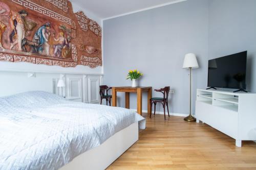 1 dormitorio con 1 cama, TV y mesa en Alt-Berliner Eckkneipe - "Feuchte Ecke" en Berlín