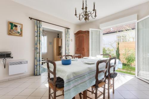 une salle à manger avec une table et des chaises dans l'établissement Escale avec jardin - 750m plage de la Jetée, à Andernos-les-Bains