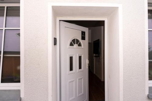 białe drzwi prowadzące do korytarza w domu w obiekcie Cosy Nest - Apartment by Comfort Housing w mieście Falkensee