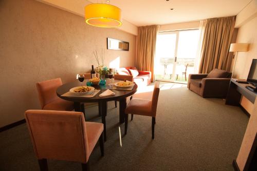 a living room with a table and chairs and a living room at Epic Hotel San Luis in La Punta
