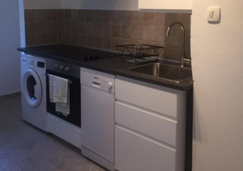 a kitchen with a sink and a washing machine at Apartments Vila Miranda 2 in Barbat na Rabu