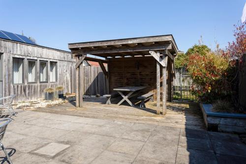 a picnic shelter with a picnic table on a patio at Hunzego Hotel in Uithuizermeeden