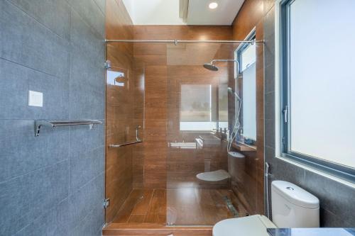 a bathroom with a shower with a toilet and a sink at Villa Days Bali in Jimbaran