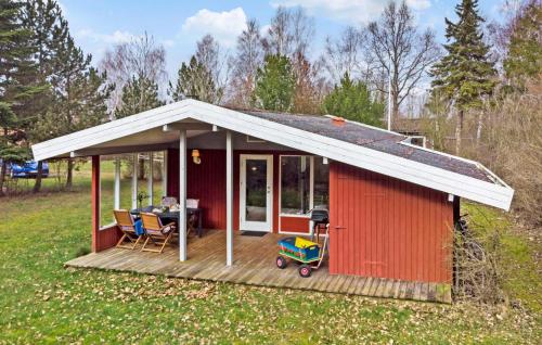 a red shed with a white roof and a table at 3 Bedroom Awesome Home In Nysted in Nysted