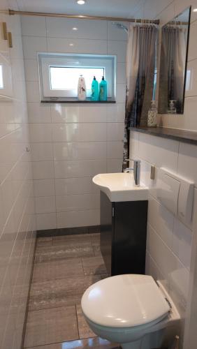 a bathroom with a toilet and a sink at Vakantiehuis Saffier in Simpelveld