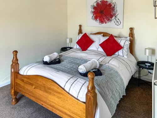 a bedroom with a bed with red and white pillows at Roseus - Uk44706 in Combe Martin