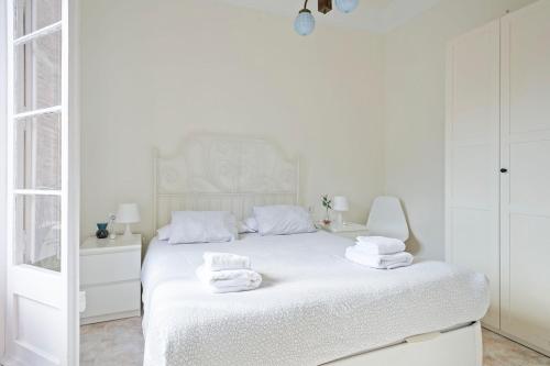 バルセロナにあるApartmento Industriaの白いベッドルーム(タオル付きのベッド付)