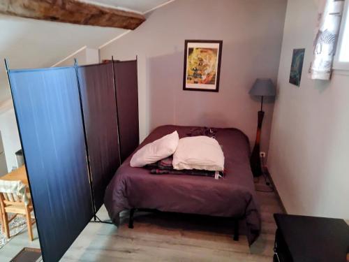 una piccola camera con letto e armadio di Studio cosy duplex dans château médiéval a Le Poujol-sur-Orb