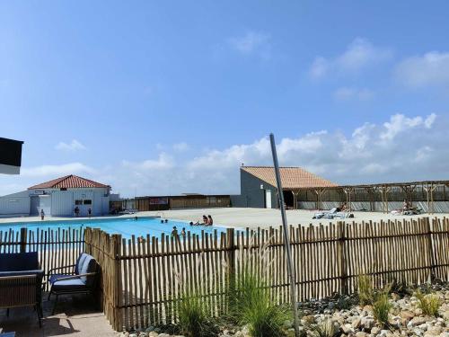 une piscine avec une clôture et des personnes. dans l'établissement Appartement T2 avec terrasse, piscine, parking - Le Barcarès - FR-1-195-46, au Barcarès