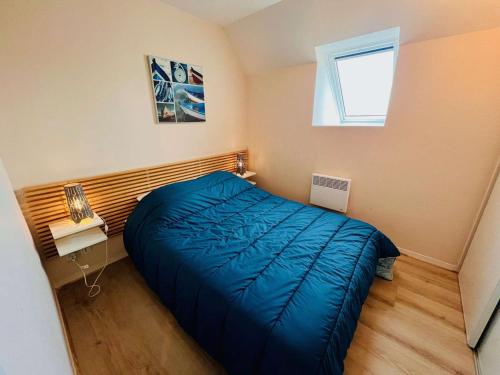 - une petite chambre avec un lit bleu et une fenêtre dans l'établissement Quiberon - Appartement 2P 33m² avec aperçu mer, balcon, parking et animaux acceptés - FR-1-478-112, à Quiberon