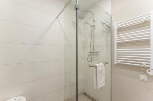 a shower with a glass door in a bathroom at Paz e Vista Mar with Pool & WiFi in Luz