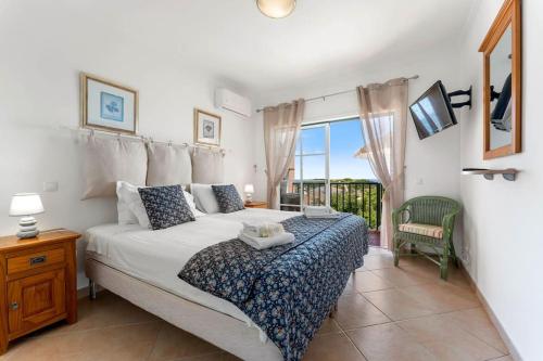 a bedroom with a large bed and a balcony at Paz e Vista Mar with Pool & WiFi in Luz