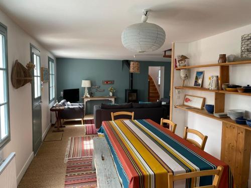 un soggiorno con un divano e un tavolo di Villa spacieuse avec jardin clos à 5 min du port de Sauzon, calme absolu, idéale famille, Wi-Fi inclus - FR-1-418-155 a Sauzon