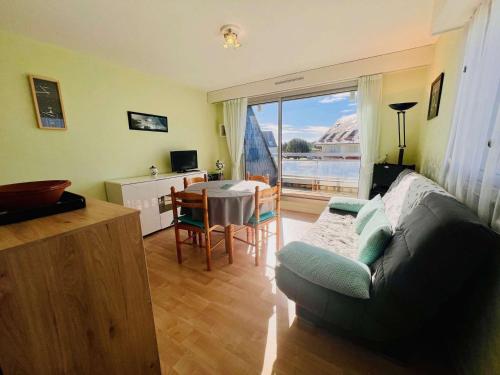 un salon avec un canapé et une table dans l'établissement Studio lumineux avec coin nuit, balcon, parking, animaux acceptés - Quiberon - FR-1-478-122, à Quiberon