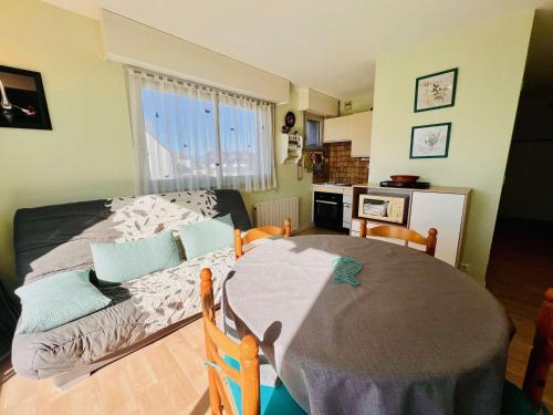 Cette chambre comprend une table, un lit et une cuisine. dans l'établissement Studio lumineux avec coin nuit, balcon, parking, animaux acceptés - Quiberon - FR-1-478-122, à Quiberon