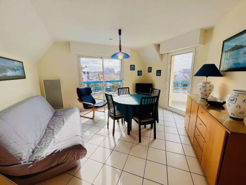 un salon avec une table, des chaises et un canapé dans l'établissement Quiberon: Charmant T3 avec terrasse, 20m de la plage, parking, animaux acceptés - FR-1-478-29, à Quiberon