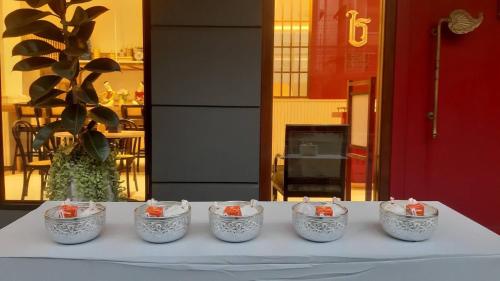 a table with four candles in buckets on it at Pranakorn Heritage Hotel in Bangkok