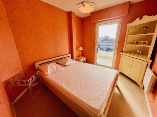 une petite chambre avec un lit et une fenêtre dans l'établissement Quiberon: Charmant T3 avec terrasse, 20m de la plage, parking, animaux acceptés - FR-1-478-29, à Quiberon