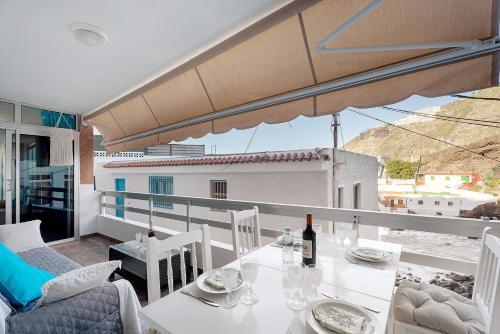 a white table with a bottle of wine on a balcony at Casa Nene in La Matanza de Acentejo