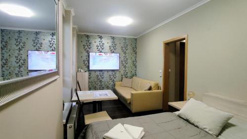 ein kleines Zimmer mit einem Bett und einem Sofa in der Unterkunft MENŠÍ APARTMÁN C307 se snídaní v ceně, s velkým balkonem a s využitím saunového světa GROTTA SPA - by Relax Harrachov in Harrachov