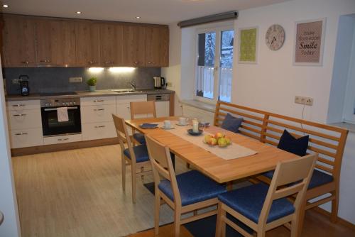 una cucina con tavolo e sedie in legno di Ferienwohnung Pia a Wald am Arlberg