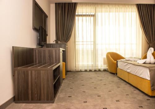a hotel room with a bedroom with a bed and a tv at Nobel Residence in Mamaia Sat/Năvodari