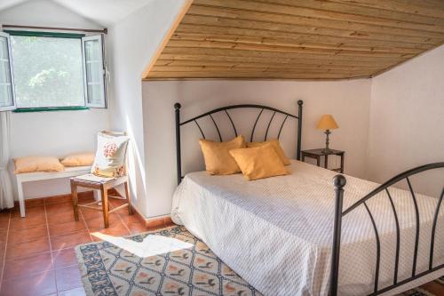 Quinta do Archino 18 في لشبونة: غرفة نوم بسرير وسقف خشبي