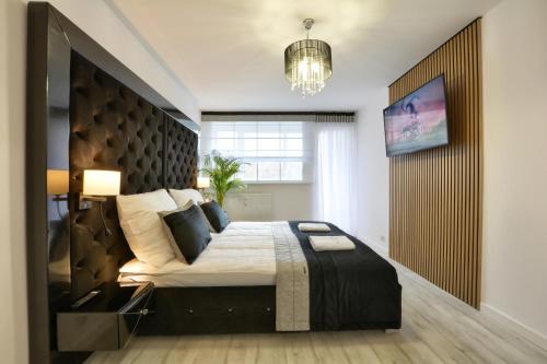 sypialnia z dużym łóżkiem z dużym zagłówkiem w obiekcie Apartament Centrum w Polanicy Zdroju