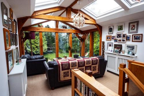 a living room with a table and a large window at High Barn in Thursley